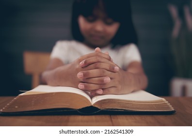 Little Girl Praying With Bible In Church