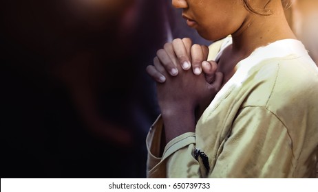 Little girl praying in the darkness .Kid hand prayer in church, spirituality and religion, Hands folded in prayer concept for faith, spirituality and religion, Coronavirus concept