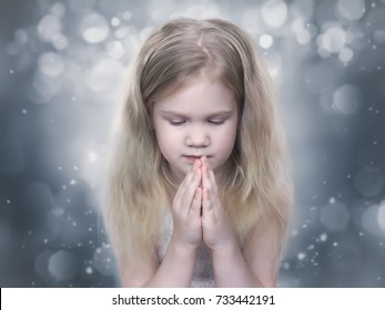 Little Girl Praying With Eyes Closed. Child Like An Angel