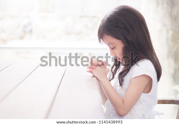 木の台の上で朝に祈る少女 小さなアジアの女の子が祈り 神に祈る子供 キリスト教 信仰 霊性 宗教の祈りのコンセプトで手を組む の写真素材 今すぐ編集