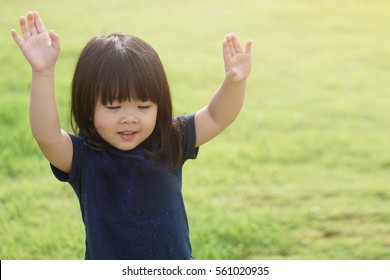 Little girl praying and raise hands in the morning for faith, spirituality and religion.