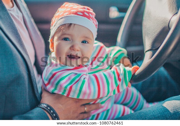 A little girl pretends to drive a car.\
Concept photo of children education, learning , drive a car,funny,\
happy, play, happiness, car\
insurance