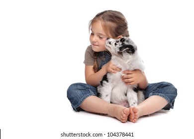 little girl and a puppy in front of a white background - Shutterstock ID 104378441