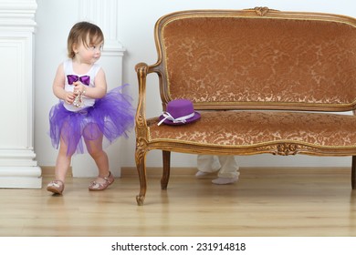 Little Girl In Purple Skirt Running Away From Boy Around Sofa