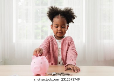 Little girl putting coin of cash into ceramic piggy bank - Shutterstock ID 2312693749