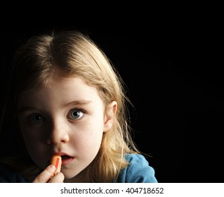 A Little Girl Putting On Chapstick