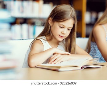 Little Girl Reading Books In Library