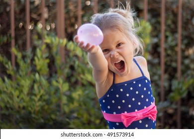 A Little Girl Ready For A Water Balloon Fight