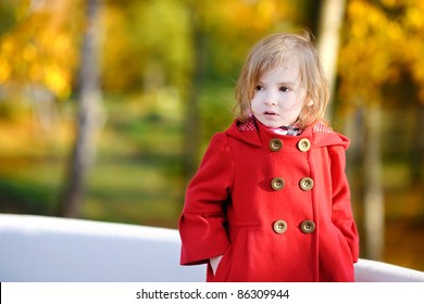 Little Girl In A Red Coat At Autumn