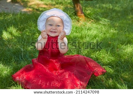 little girl in a red dress with a hat,smiling little girl with first teeth in a dress