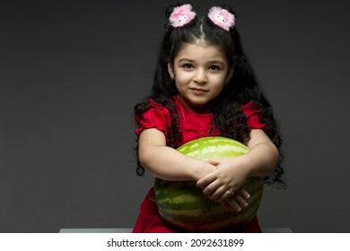 Little Girl With Red Dress Holding A Watermelon In Front Of Her. Happy Yalda Iranian Celebration Theme