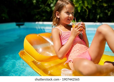 Little girl relaxing in swimming pool, enjoying suntans, drink a juice on inflatable yellow mattress in water on family vacation, tropical holiday resort