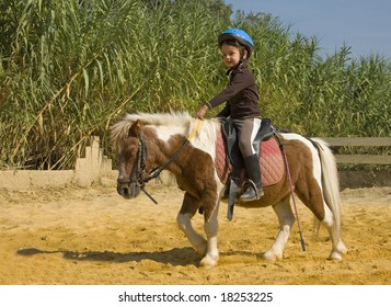 Little Girl Riding A Miniature Shetland Pony