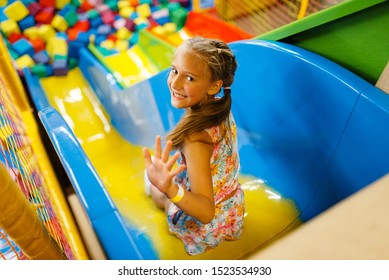 Little girl riding on plastic kids slide, playroom - Shutterstock ID 1523534930