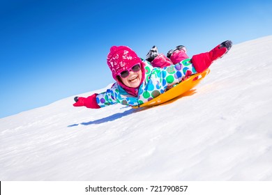 kleines Mädchen auf Schneeschlitten im Winter