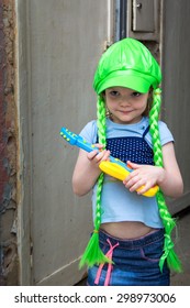 Little Girl Rock Star In A Wig With A Guitar