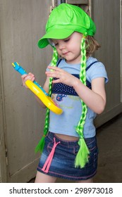 Little Girl Rock Star In Wig Play Guitar