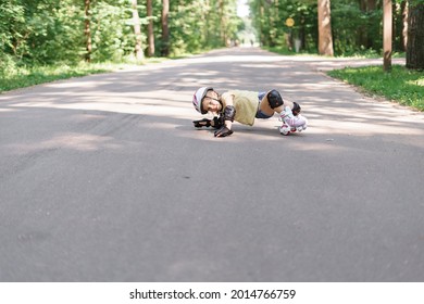 Little Girl Is Rollerblading In The Park. Baby In Protective Sportswear