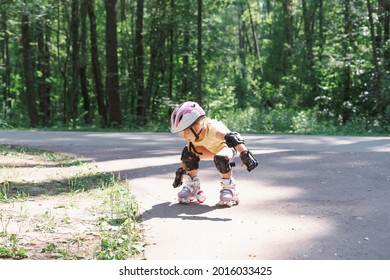 Little Girl Is Rollerblading In The Park. Kid In Protective Sportswear