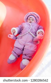 Little Girl Rolling Downhill On A Winter Day