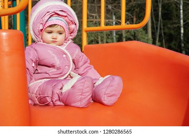 Little Girl Rolling Downhill On A Winter Day