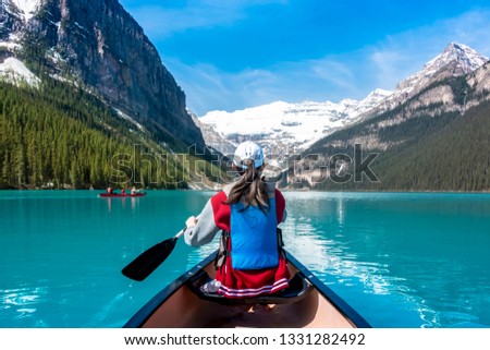 The little girl is rowing in Lake Louise, Canada.
