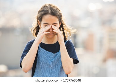 Little girl rubbing her irritated eyes outdoors