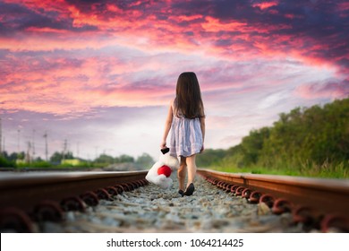 a little girl run away home on the railway, walking lonely ahead without destination