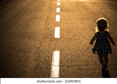 Little Girl Running Away On The Road Ahead