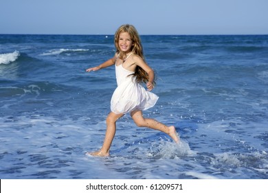 Little girl running beach shore splashing water in blue sea - Powered by Shutterstock