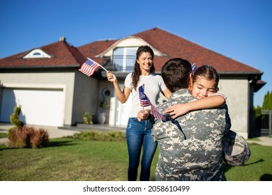 Little Girl Running To Her Dad Soldier Coming Home From War And His Beautiful Wife Waving American Flags.