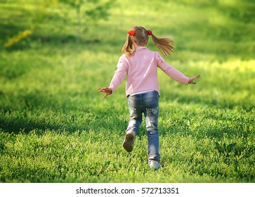 Little Girl Running On The Grass Back