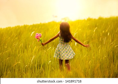 Little Girl Running On Meadow With Sunset