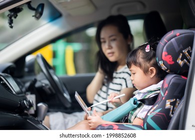 Little Girl In School Uniform Using Tablet In Baby Carseat 