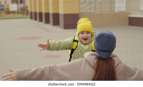 Little Girl Schoolgirl With Backpack Runs Hug Her Mother, Kid Rejoice Over Lessons, Happy Family, School Bag Behind Back Cheerful Laughing Child, Baby Hurries Her Mother Her Arms, Jogging School Yard