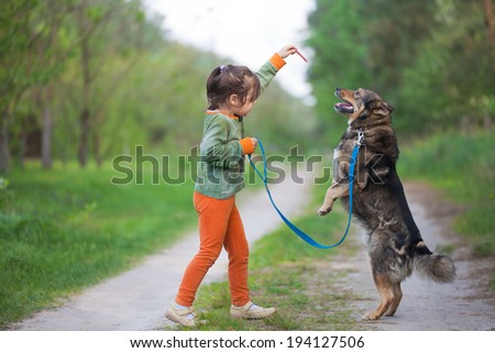 Little girl schooling dog outdoor