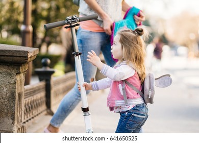 Little girl and scooter on a city street