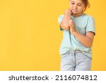 Little girl scratching herself on color background