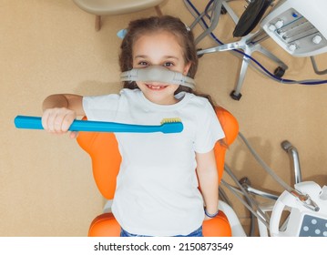 little girl with sedation mask.Treatment of children's teeth with nitrous oxide.children's dentistry. - Shutterstock ID 2150873549