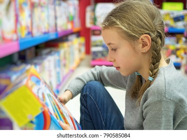 Little Girl Selecting Toy In Kids Store.