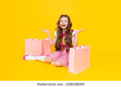A little girl shopping after a big sale. Children's shopping. Gifts for children. Bags with clothes and shopping.