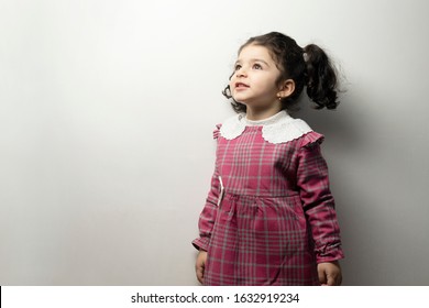 Little girl with side pony hairstyle looking outside of frame, childhood memories concept