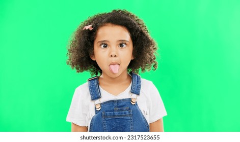 Little girl, silly and goofy face on green screen with facial expressions against a studio background. Portrait of female child or kid making funny faces with tongue out for childhood youth on mockup