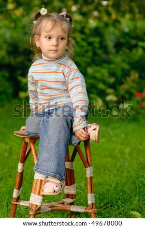 Similar – Adorable little girl playing with a ball sitting on a park bench