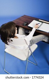 Little Girl Sitting In Bad Posture On Chair In Classroom