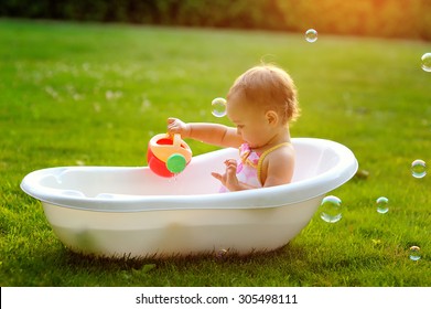 little girl sitting in the bath.