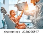 A little girl is sitting in a dentist