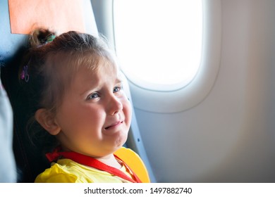 Little Girl Sitting Next To Mother Screaming On Airplane