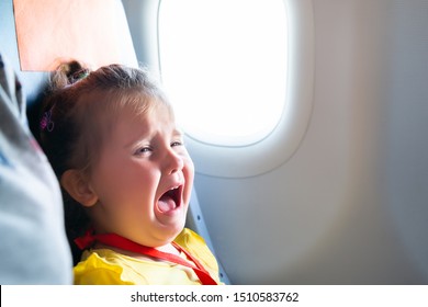 Little Girl Sitting Next To Mother Screaming On Airplane