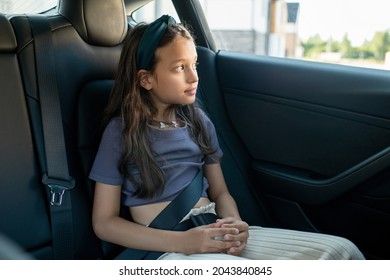 Little Girl Sitting On Backseat Of New Comfortable Electric Car And Looking Through Window